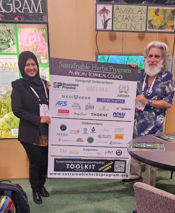 Haliza Ramli and Mark Blumenthal standing either side of an American Botanical Council board at a trade show